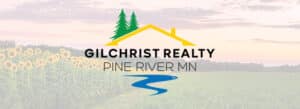 A logo with a yellow house roof, two green pine trees, and a blue river stream. Behind the logo, the background shows a field of sunflowers and a distant treeline under a partly cloudy sky. Text reads "Gilchrist Realty, Pine River, MN".