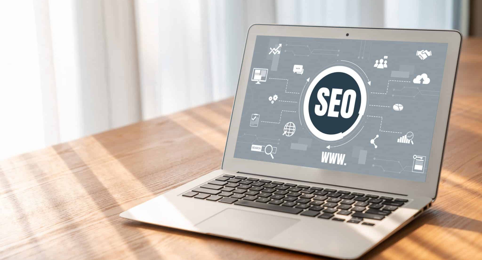 A laptop on a wooden table showcases an SEO graphic, labeled "SEO 2025" in bold letters. This forward-thinking display is surrounded by icons symbolizing digital concepts such as networking, analytics, and web development to help boost your website's SEO effectively.