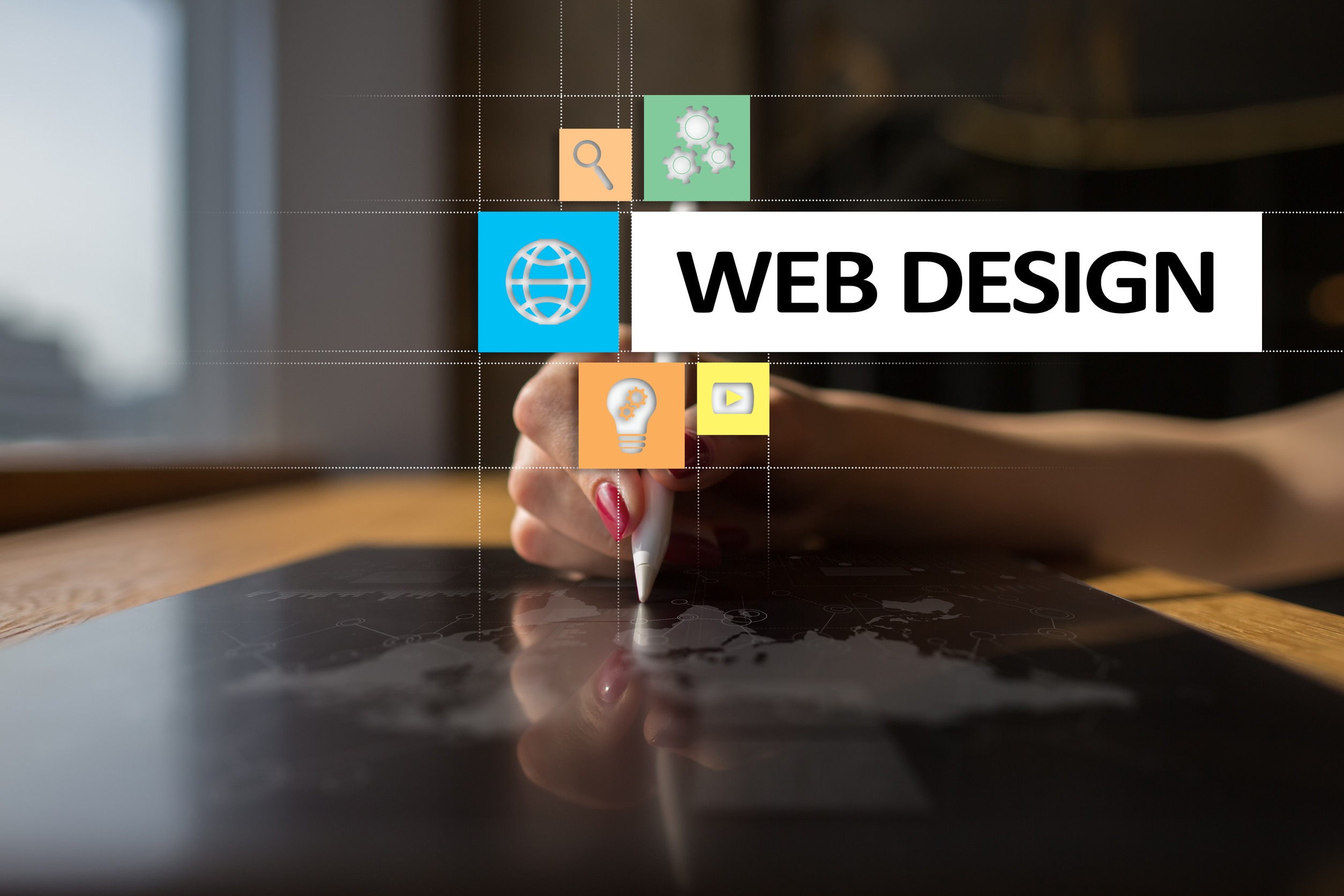 A person uses a stylus on a tablet, with web design-themed icons and the text "WEB DESIGN" digitally overlaid on the image. The scene suggests modern digital design and technology.