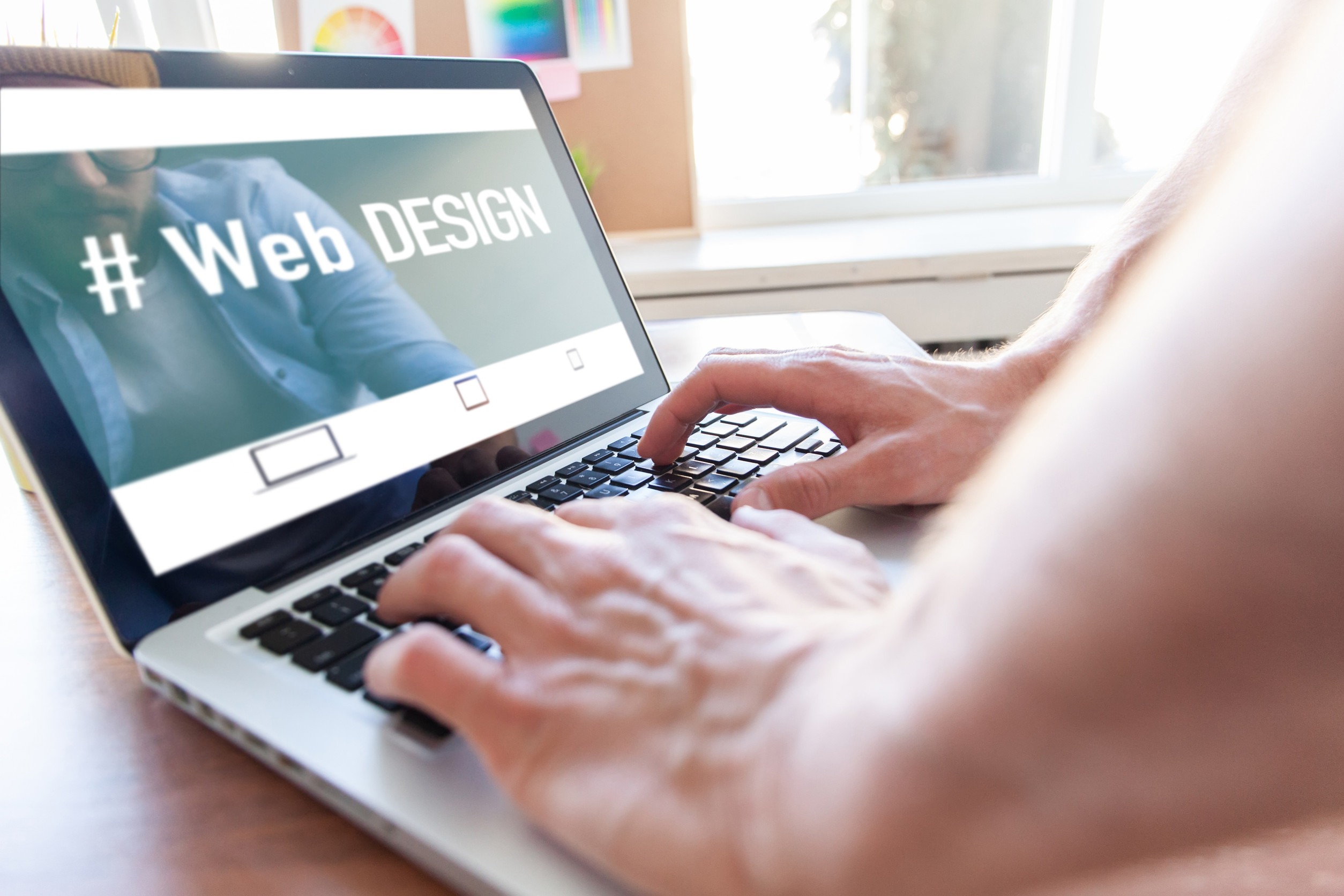 A person types on a laptop showing a screen with the words 