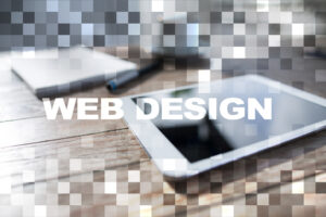 A tablet, notebook, and pen rest on a wooden desk with a pixelated effect overlay. "WEB DESIGN" appears in large white letters across the center, highlighting Minnesota business growth through creative web solutions.