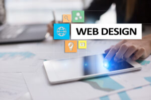 A person using a tablet at a desk with charts and a laptop, overlaid with icons and the words "WEB DESIGN" in bold text.