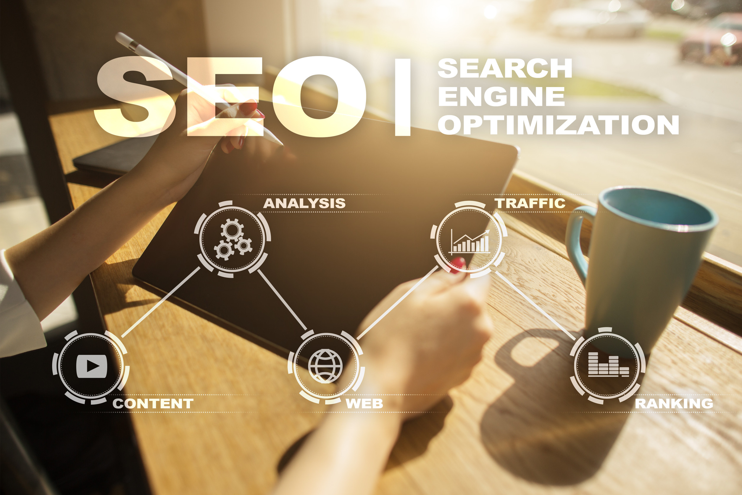 A person writes in a notebook beside a tablet and coffee mug, surrounded by SEO graphics and text like "Search Engine Optimization," illustrating website strategies that drive traffic, boost ranking, and inspire confidence for business growth.