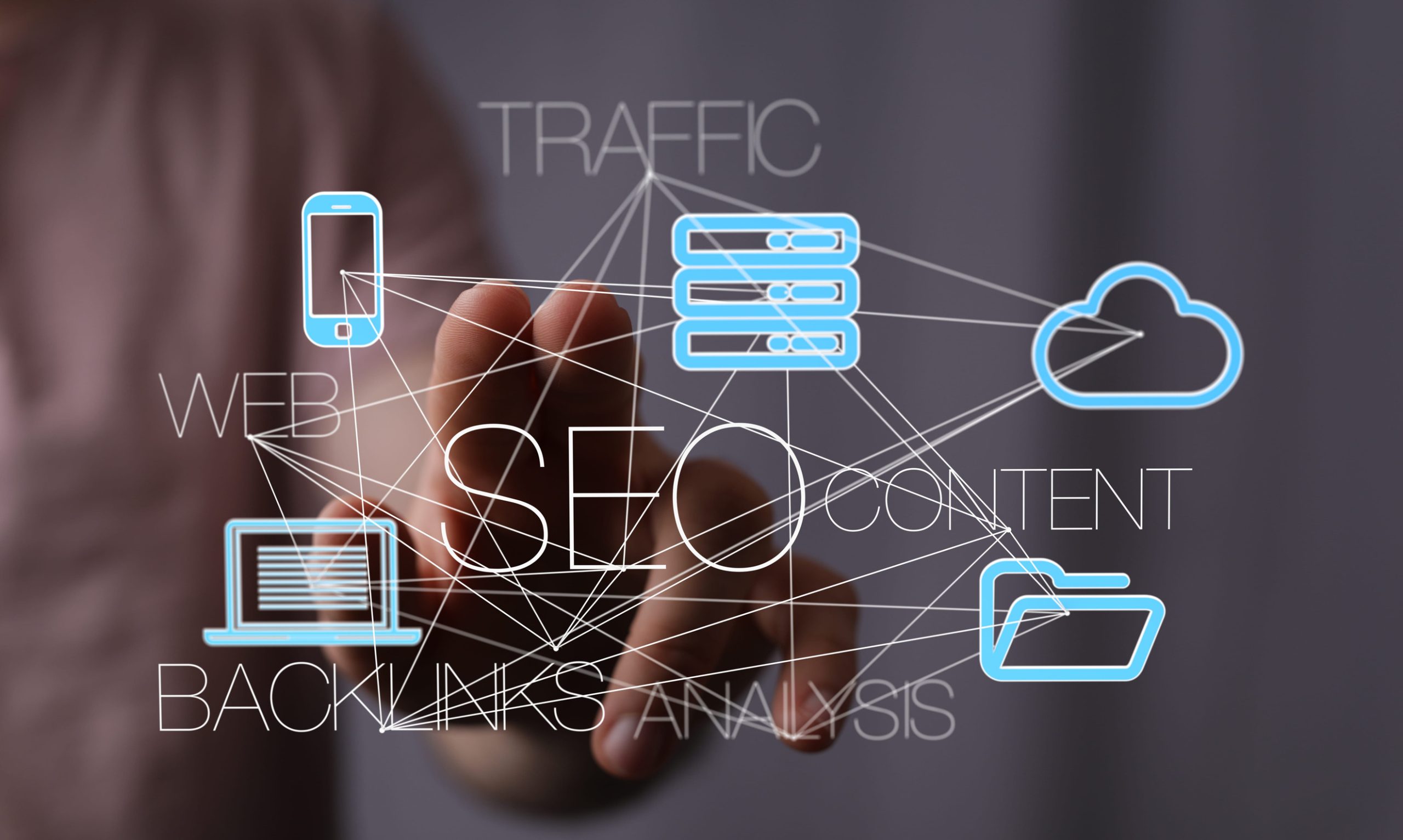 A hand reaching toward a digital SEO strategy diagram featuring icons for mobile, server, cloud, laptop, and folder, connected by lines and text labels.
